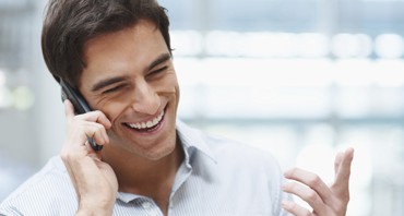 Laughing young guy enjoying a conversation over the cellphone Laughing young guy enjoying a conversation over the cellphone